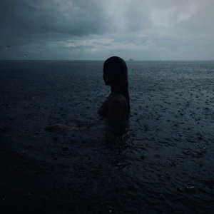 Billie eilish with rain in the background